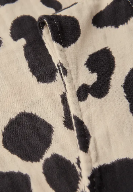 Stoff mit schwarz-weißen Leopardenmuster und einer sichtbaren Naht.